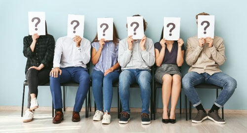 group of people holding question marks